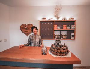 a woman standing behind a table with a cake at Hotel Garni Almjur in Sankt Anton am Arlberg