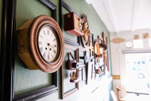 a clock is hanging on a wall with pictures at Hôtel Le Patio - Deauville in Deauville