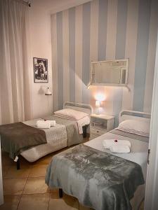 Zimmer mit 2 Betten und einem Spiegel in der Unterkunft All Suite Colosseo in Rom