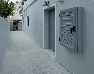 una puerta en el lateral de un edificio con una acera en Αcacia House - Fully Equipped Apartment in Glyfada en Atenas