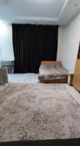 1 dormitorio con cama y cortina negra en Бухар жырау 45 en Karagandá