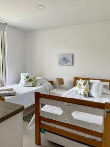 a bedroom with two beds and a window at CONDOMINIO ZAZUE, SANTA MARTA, PLAYA BELLO HORIZONTE wifiiiii in Santa Marta