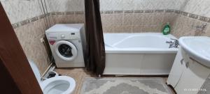 a bathroom with a washing machine and a toilet at Бухар жырау 45 in Karagandy