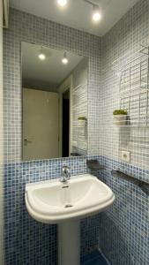 a bathroom with a sink and a mirror at LC Apartamentos César Augusto in Zaragoza