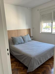 1 dormitorio con 1 cama grande con almohadas azules en Departamento de 1 dormitorio - Zona parque independencia en Rosario