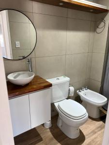 a bathroom with a toilet and a sink and a mirror at Departamento de 1 dormitorio - Zona parque independencia in Rosario