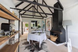 a living room with a table and a fireplace at Bitou River Lodge in Plettenberg Bay