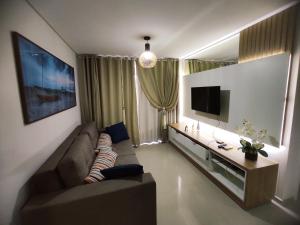 sala de estar con sofá y TV de pantalla plana en Res Mirante 103, en Bombinhas