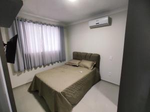 1 dormitorio con 1 cama en una habitación con ventana en Res Mirante 103, en Bombinhas