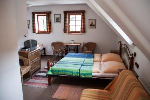 a bedroom with a bed and a living room at Penzion Kříž in Český Krumlov