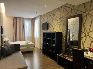 - une chambre d'hôtel avec un lit et un miroir dans l'établissement Catone District Hotel, à Rome