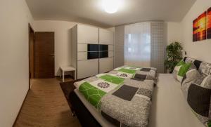 - une chambre avec un lit doté d'une couette verte et grise dans l'établissement Appartements Haidl, à Sankt Johann im Pongau