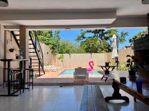 una sala de estar con piscina y una casa en Colibrí Hostel en Puerto Iguazú