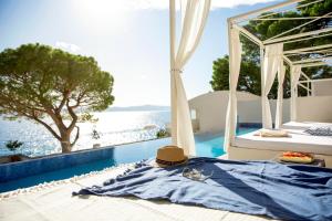 a bed with a hat and a view of a pool at TUI BLUE Makarska - Adults Only in Igrane