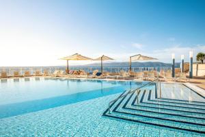 a large swimming pool with chairs and umbrellas at TUI BLUE Makarska - Adults Only in Igrane