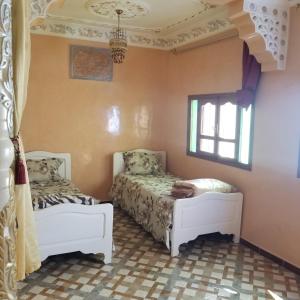 une chambre avec deux lits et une fenêtre dans l'établissement appartement traditionnel, à Taghazout