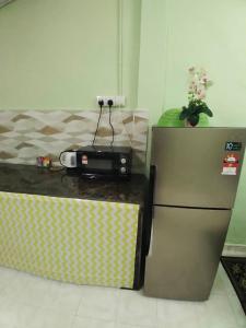 マスジッド・タナにあるGreen Home Homestay Melakaのキッチン(コンロ、冷蔵庫付)
