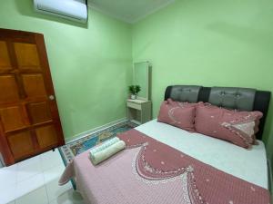 マスジッド・タナにあるGreen Home Homestay Melakaのベッドルーム1室(ピンクの枕と鏡付きのベッド1台付)