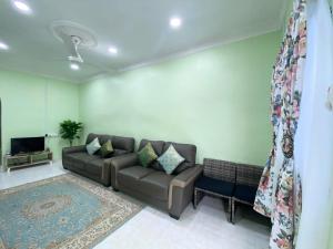 a living room with a couch and a tv at Green Home Homestay Melaka in Masjid Tanah