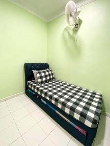 a room with a black and white couch with a fan at Green Home Homestay Melaka in Masjid Tanah