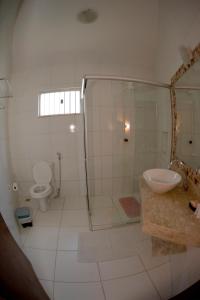 a bathroom with a shower and a sink and a toilet at Pousada Mar de Estrelas in São Miguel do Gostoso