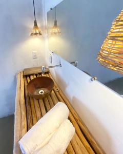 a bathroom with a wooden toilet and two towels at Quintal do Céu Caraíva in Porto Seguro