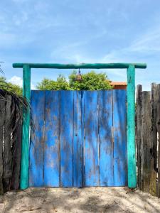 an old blue gate in front of a fence at Quintal do Céu Caraíva in Porto Seguro