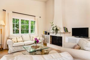 a living room with white furniture and a fireplace at 3010 - Schönes mediterranes Ferienhaus in Costa de la Calma in Costa de la Calma