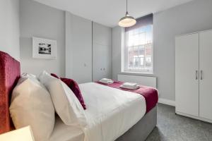 un dormitorio con una cama y una ventana en Roomspace Serviced Apartments - Brewers Lane, en Richmond