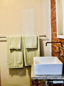 a bathroom with a white sink and towels at Ladybird in Durban
