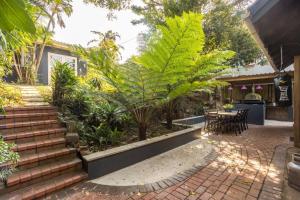 a patio with stairs and plants and a table at Ladybird in Durban