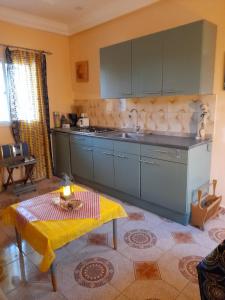 a kitchen with gray cabinets and a table in a room at flowerhouse Sukuta Gambia in Sukuta