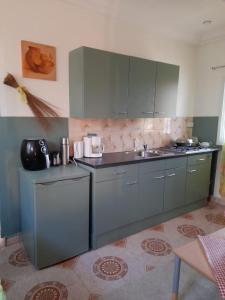 a kitchen with gray cabinets and a sink at flowerhouse Sukuta Gambia in Sukuta