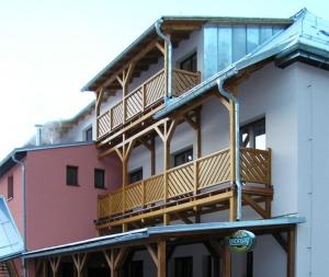 a building with wooden balconies on the side of it at Penzion a restaurace Sklář in Karolinka