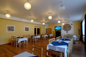 a dining room with tables and chairs and a television at Penzion a restaurace Sklář in Karolinka