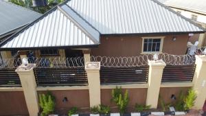 a house with a fence in front of it at Living Green APARTMENTS AIRPORT PICK UP in Benin City