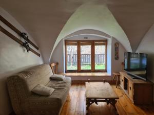 a living room with a couch and a tv at Le Préau in Ornon