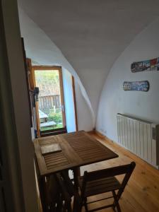Habitación pequeña con mesa de madera y ventana. en Le Préau, en Ornon 7 fotos más