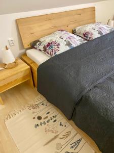 1 dormitorio con cama, mesa y alfombra en CampHouse en Chvalšiny