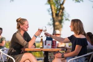 a man and woman sitting at a table with glasses of wine at Pod aan het water in Dokkum