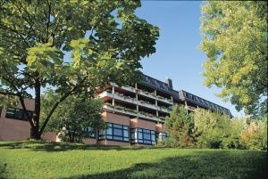 ein Gebäude mit einem Baum davor in der Unterkunft Hotel an der Therme in Bad Orb
