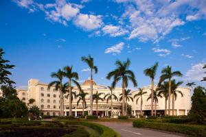 a building with palm trees in front of it at Khách sạn Quốc tế Lợi Lai - Li Lai International Hotel in Móng Cái