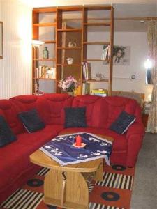 1 sofá rojo con mesa en la sala de estar en Ferienwohnung Klingelhöfer E-III-2-6, en Altenau