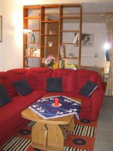 1 sofá rojo con mesa en la sala de estar en Ferienwohnung Klingelhöfer E-III-2-6, en Altenau