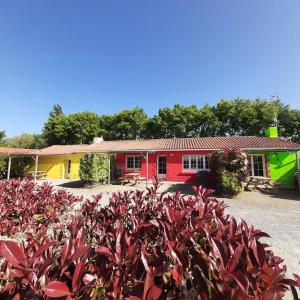 ein Haus mit einem roten und gelben Haus in der Unterkunft Gîtes Les P'tites Maisons dans la Prairie in Sallertaine