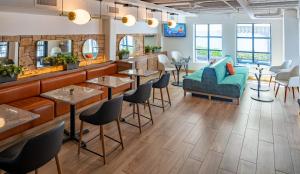 ワシントンにあるARC HOTEL Washington DC, Georgetownのテーブルと椅子とソファのあるレストラン