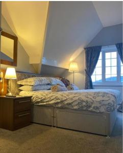 a bedroom with a large bed with blue curtains at The Wayfarer, Robin Hoods Bay in Whitby