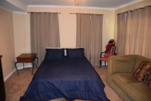 a bedroom with a bed and a couch at Luxury Home Stay in Loganville