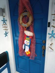 een blauwe deur met een sneeuwpop versiering erop bij Anilao Cliffhouse in Mabini