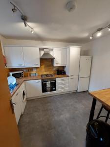 a kitchen with white appliances and a wooden table at bankwellstreet in Manchester